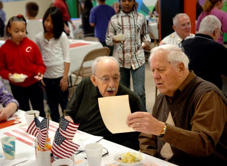Samuel Hoffman/The Journal Gazette, Fort Wayne, Ind.: Navy veterans Ed Schulz, left, and Raymond Moyer look at old photos at Holland Elementary. Area veterans were guests of honor at a school luncheon.